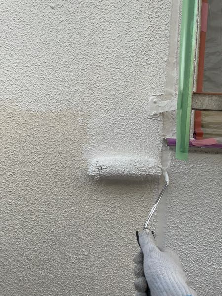 外壁をシーラーで下塗りしています。