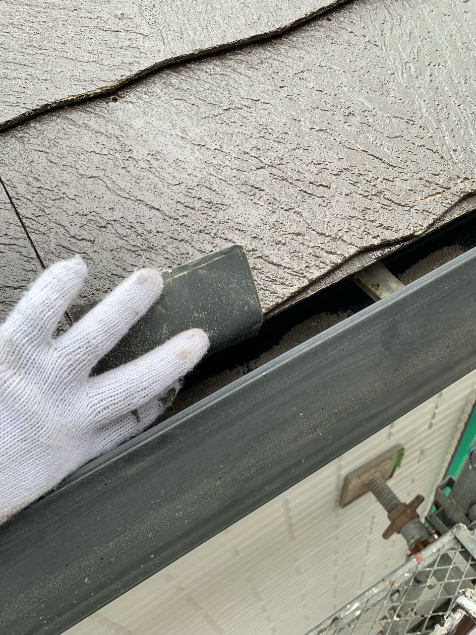 ペーパーを使い表面に微細な傷を付けています。
傷を付けることにより、塗料の付着性が上がります。塗膜が長期にわたり剥がれてこないようにする下処理です。
唐草は屋根材の奥にある水切り板金です。わかりにくいところです💦
細かなところですが確実に工程をこなします。